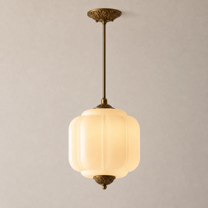 Vintage-style pendant light with white milk glass shade and brass fixture on a neutral background