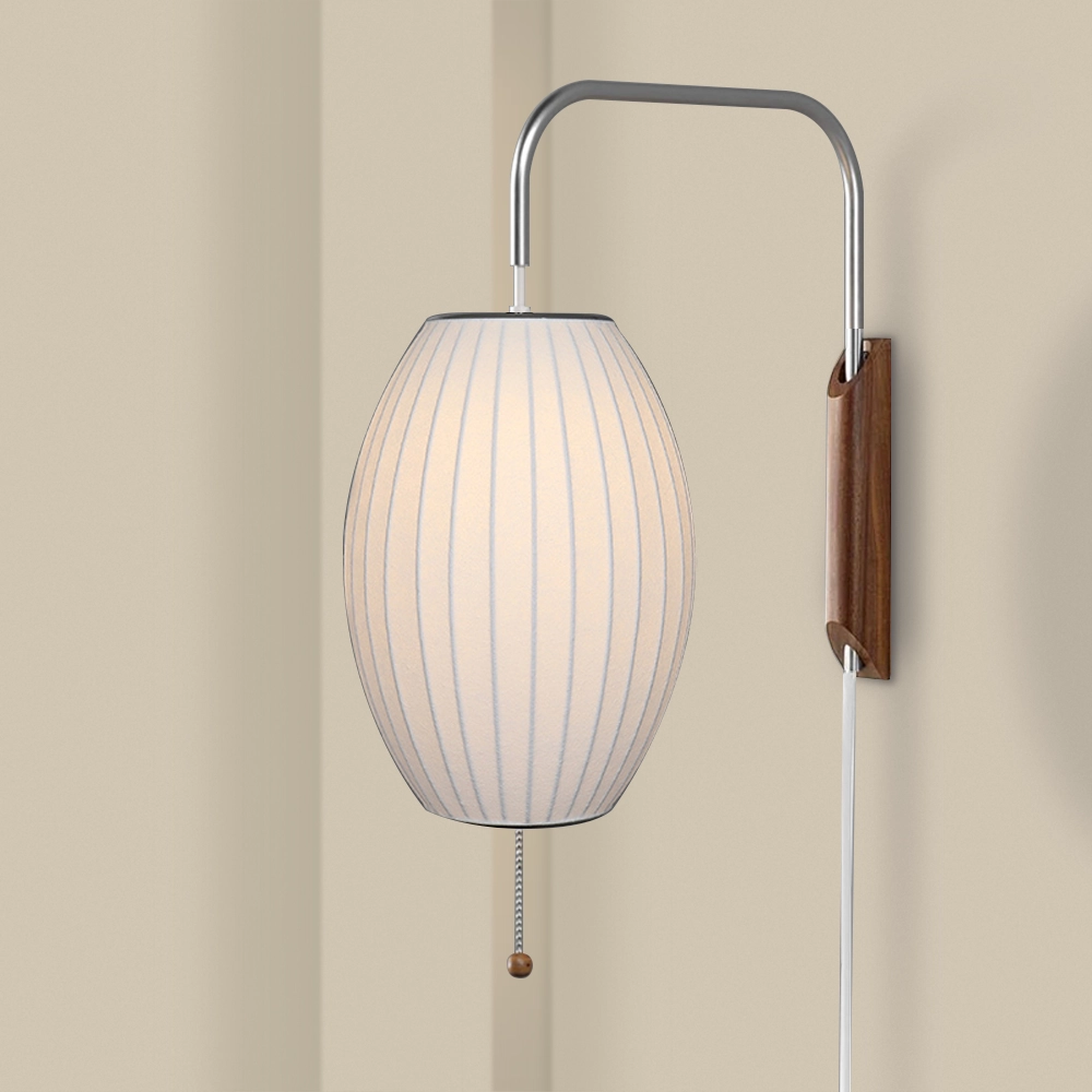 A wall-mounted lamp with a silk shade and a wooden and metal base, featuring a pull string switch.